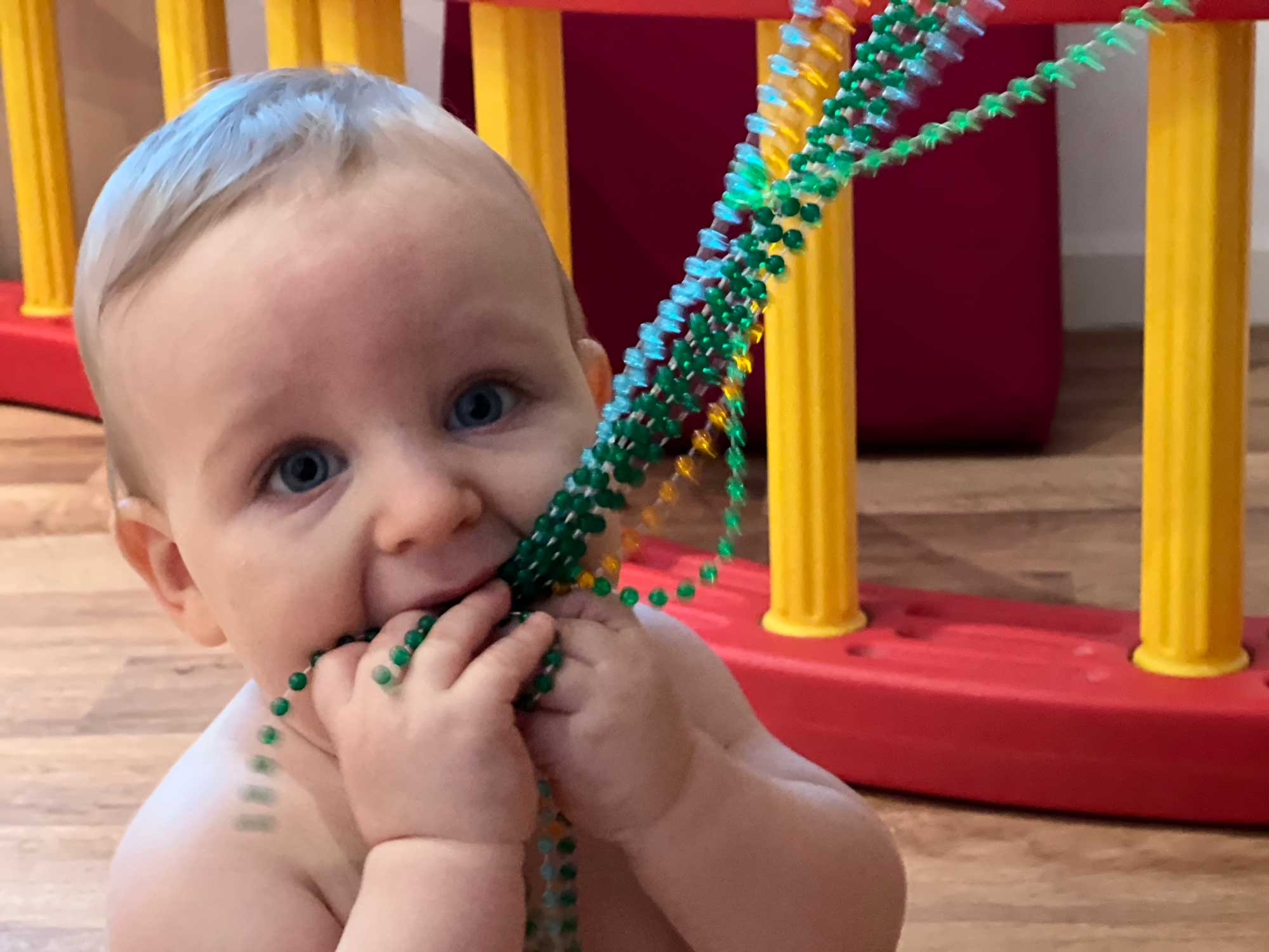 Baby spielt mit Ketten im PerBabyMobile